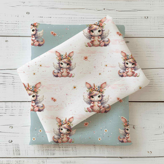 Osterstoff als Jersey oder French Terry mit Einhorn Osterhase und floralen Details auf hellem Hintergrund, perfekt für kreative Nähprojekte