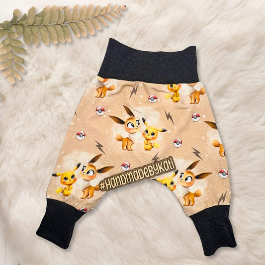 handmde baby hose auf beige farbenden Pokemon Stoff mit dunkel grauem Bündchen. Pokemon sind Pikatchu und evoli.