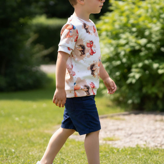 Kind trägt ein Handmade Kinder T-Shirt aus Rib Jersey mit süßem Drachen und Igel Motiv – bequemes Sommer Shirt für Jungen und Mädchen